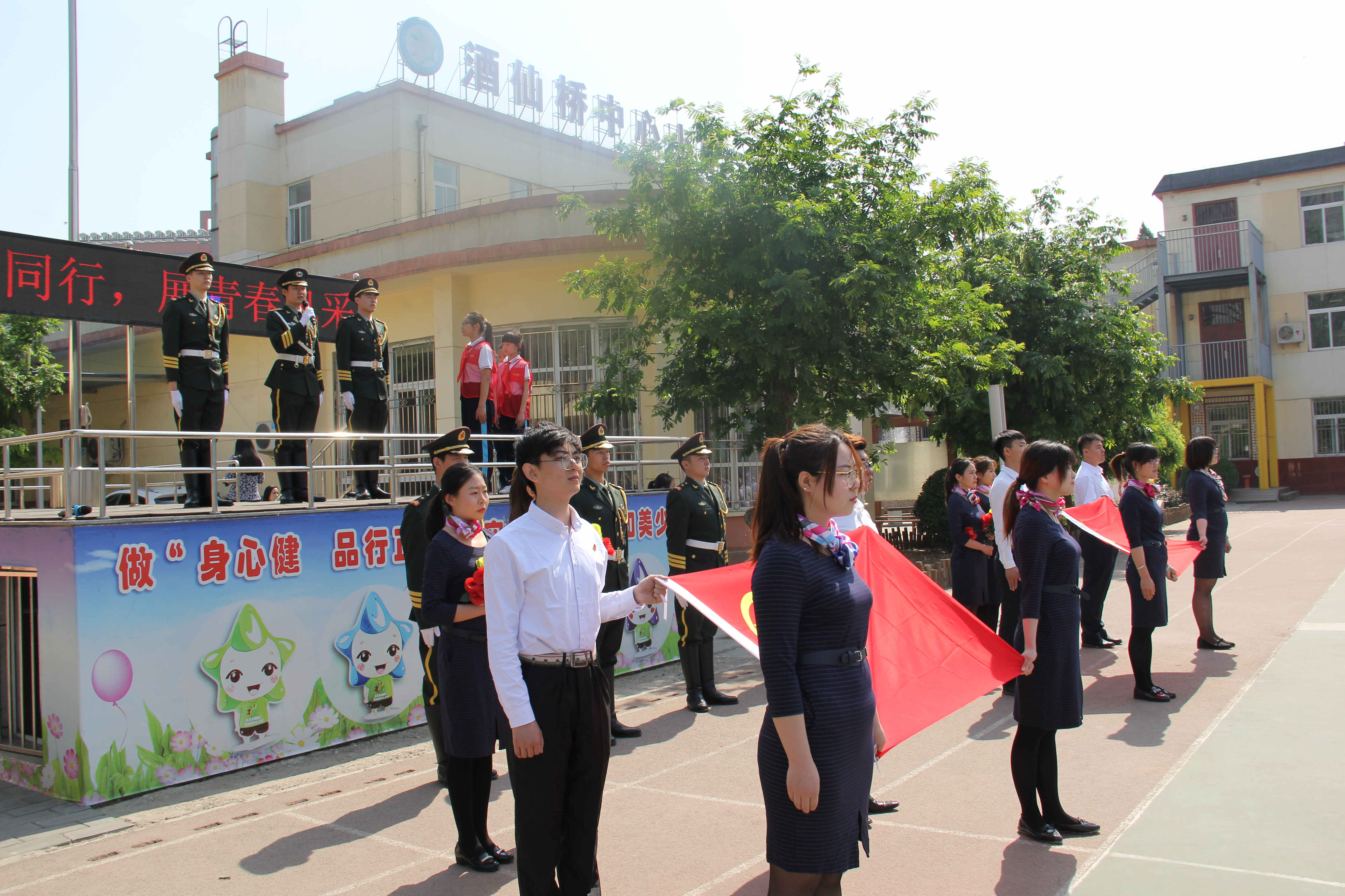 天安门国旗班战士同酒仙桥中心小学教师共升国旗