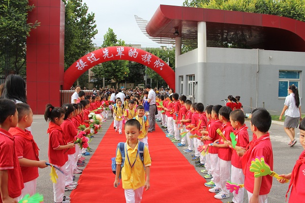 北师大大兴附小学校领导站在门口迎接新生入学